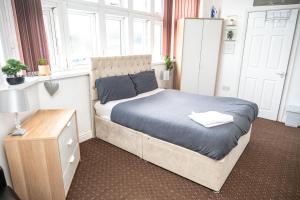 een slaapkamer met een groot bed en een raam bij Bvapartments Deighton in Huddersfield
