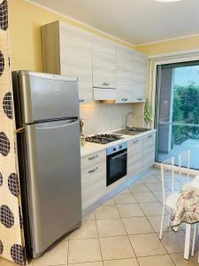 una cucina con frigorifero in acciaio inossidabile e piano cottura di SUITE GARDEN-MARINA SVEVA a Marina di Montenero