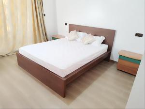 een bed met witte lakens en kussens in een kamer bij ferme privé avec piscine in Safi