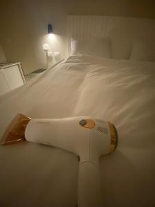 a remote control laying on a white bed at Dyafa Suites Giza in Cairo