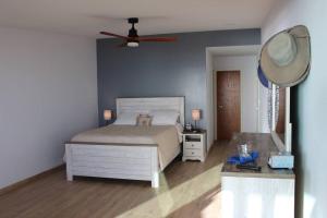 um quarto com uma cama e uma ventoinha de tecto em Oceanfront Home in Rosarito Beach em Santa Mónica Sur