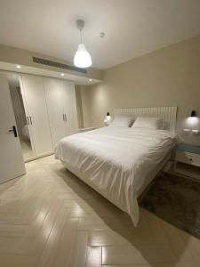a bedroom with a large white bed in a room at Dyafa Suites Giza in Cairo