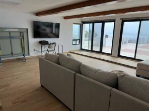 a living room with a couch and large windows at Oceanfront Home in Rosarito Beach in Santa Mónica Sur