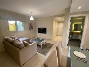 a living room with a couch and a table at Dyafa Suites Giza in Cairo +12 photos