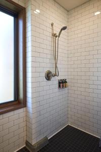 a shower in a white tiled bathroom with a window at Eritage Resort in Walla Walla