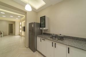 a kitchen with a counter top and a refrigerator at Dyafa Suites Giza in Cairo