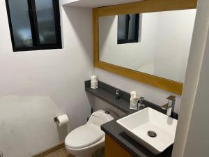 a bathroom with a toilet and a sink and a mirror at Oceanfront Home in Rosarito Beach in Santa Mónica Sur +16 photos