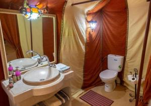 a bathroom with a sink and a toilet in a tent at Merzouga Desert tented Camp in Merzouga