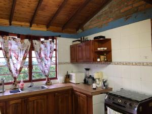 cocina con fregadero, fogones y ventanas en Villa Ines, en Playa Verde