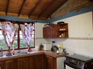 a kitchen with a sink and a stove and windows at Villa Ines in Playa Verde