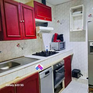 a small kitchen with red cabinets and a microwave at Appartement à louer 180 m² sur la route nationale in Mérina