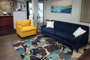 a living room with a blue couch and a yellow chair at Comfort Inn Yreka I-5 in Yreka