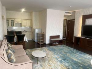 a living room with a couch and a kitchen at Best Western Plus Astana Hotel in Astana