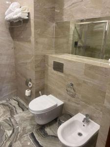a bathroom with a white toilet and a sink at Best Western Plus Astana Hotel in Astana