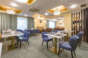 a dining room with tables and blue chairs at Best Western Plus Astana Hotel in Astana