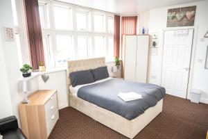 a bedroom with a bed with a blue comforter at Bvapartments Deighton in Huddersfield