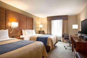 a hotel room with two beds and a flat screen tv at Comfort Inn & Suites Presidential in Little Rock