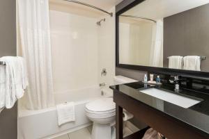 La salle de bains est pourvue d'un lavabo, de toilettes et d'un miroir. dans l'établissement Comfort Inn Thunder Bay, à Thunder Bay