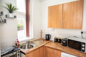 a small kitchen with a sink and a microwave at Bvapartments Deighton in Huddersfield