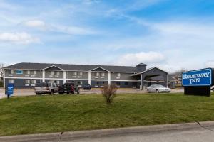 un hotel con coches estacionados frente a un edificio en Rodeway Inn, en Red Oak