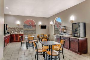 un restaurante con mesa y sillas y una cocina en Rodeway Inn, en Red Oak