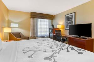 a hotel room with a bed and a flat screen tv at Sleep Inn & Suites Idaho Falls Gateway to Yellowstone in Idaho Falls