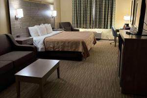 a hotel room with a bed and a couch at Quality Inn near I-72 and Hwy 51 in Forsyth