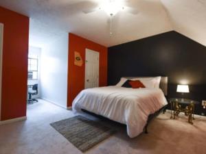 a bedroom with a large bed and red walls at The Glory Glory Doghouse Main House Huge Yard in Athens