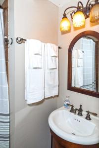 a bathroom with a sink and a mirror and towels at Americana Cottage Closest Historic BnB to Benning in Columbus
