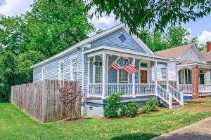 una casa con una bandiera americana sul portico anteriore di Americana Cottage Closest Historic BnB to Benning a Columbus