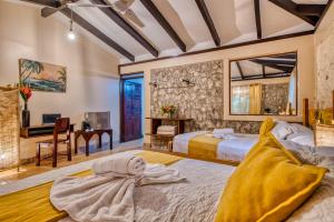 a bedroom with two beds and a desk at Atlantida Lodge Cahuita in Cahuita