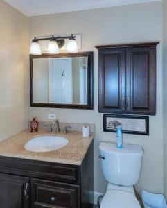 a bathroom with a sink and a toilet and a mirror at Near Fort Moore & Downtown - Our White House in Columbus