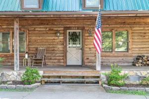 a house with an american flag in front of it at Campbell Log Cabin! Historic Charm, Modern Luxury in Clarksville