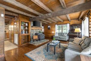 a living room with a couch and a fireplace at Campbell Log Cabin! Historic Charm, Modern Luxury in Clarksville