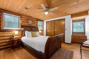 Campbell Log Cabin! Historic Charm, Modern Luxury في كلاركسفيل: غرفة نوم بسرير ومروحة سقف