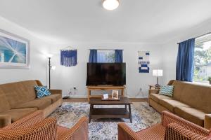uma sala de estar com 2 sofás e uma televisão de ecrã plano em Elegant in Noir- Midcentury Modern Vibes em Chattanooga
