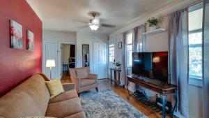 a living room with a couch and a flat screen tv at Retro Rainbow at Herb River- Flamingo Flat #4 in Savannah