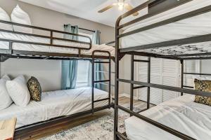 a bedroom with three bunk beds in a house at The Groovy Getaway on Garfield in Savannah
