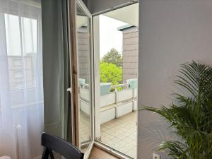 a glass door leading to a bathroom with a tub at JUNX Bude in Marl