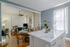 a kitchen with a white counter and a dining room at Pretty Peach Palace-Historic, Mins to Downtown in Mobile