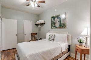 - une chambre avec un lit blanc et un ventilateur de plafond dans l'établissement Dauphin District Darling #1-Downtown, Restaurants, à Mobile