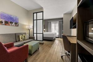 - un salon avec un canapé et un lit dans une chambre dans l'établissement Comfort Suites Charleston West Ashley, à Charleston
