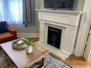 a living room with a fireplace with a tv above it at Dauphin District Darling #1-Downtown, Restaurants in Mobile