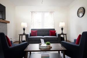 a living room with a couch and two red pillows at Norwood Nugget-Tee Off at Top Golf, Historic Charm in Birmingham