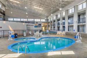 a pool in a building with tables and chairs at Clarion Inn in Murfreesboro