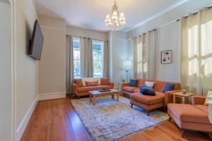 a living room with two couches and a tv at Mighty Mildred- Historic-Walkable-Mins to Riverwalk in Columbus