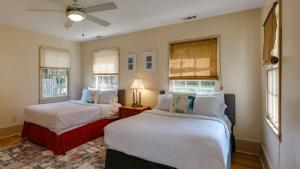 two beds in a room with two windows at Humbly Happy on Hope Isle-Island Feel-Large Yard-Private in Savannah