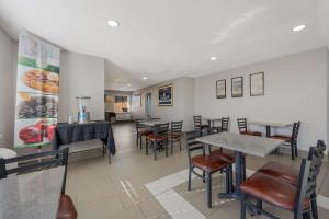 ファームビルにあるQuality Inn University Areaのレストラン内のテーブルと椅子のあるダイニングルーム