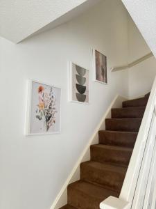 a staircase with three pictures on the wall at Mallard house in Kent