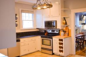 a kitchen with white cabinets and a stove top oven at Perfectly Modern Craftsman- close to everything! in Mobile